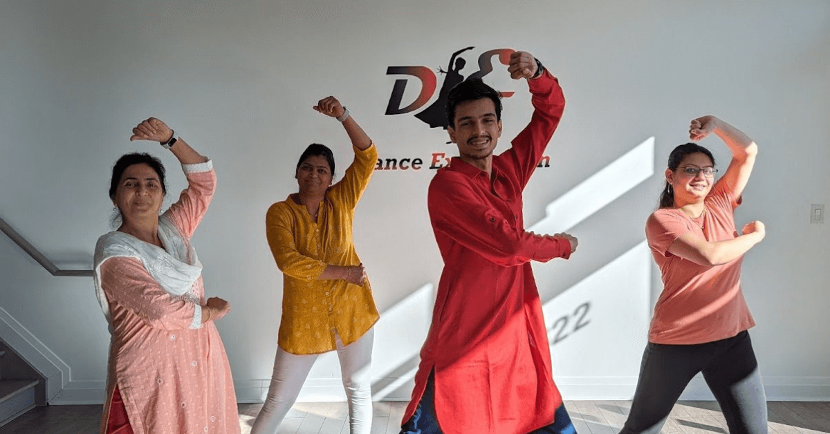 Instructor Deep leads a Garba dance workshop at Dance Expression Studio, with participants in colorful attire following his steps in a sunlit, spacious studio.